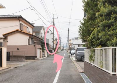 左手に見える白いタイル張りの3階建